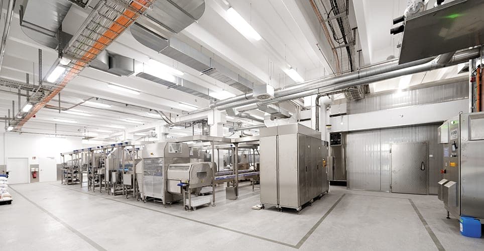 Production hall with packaging lines, ventilation ducts and the door to a cold store
