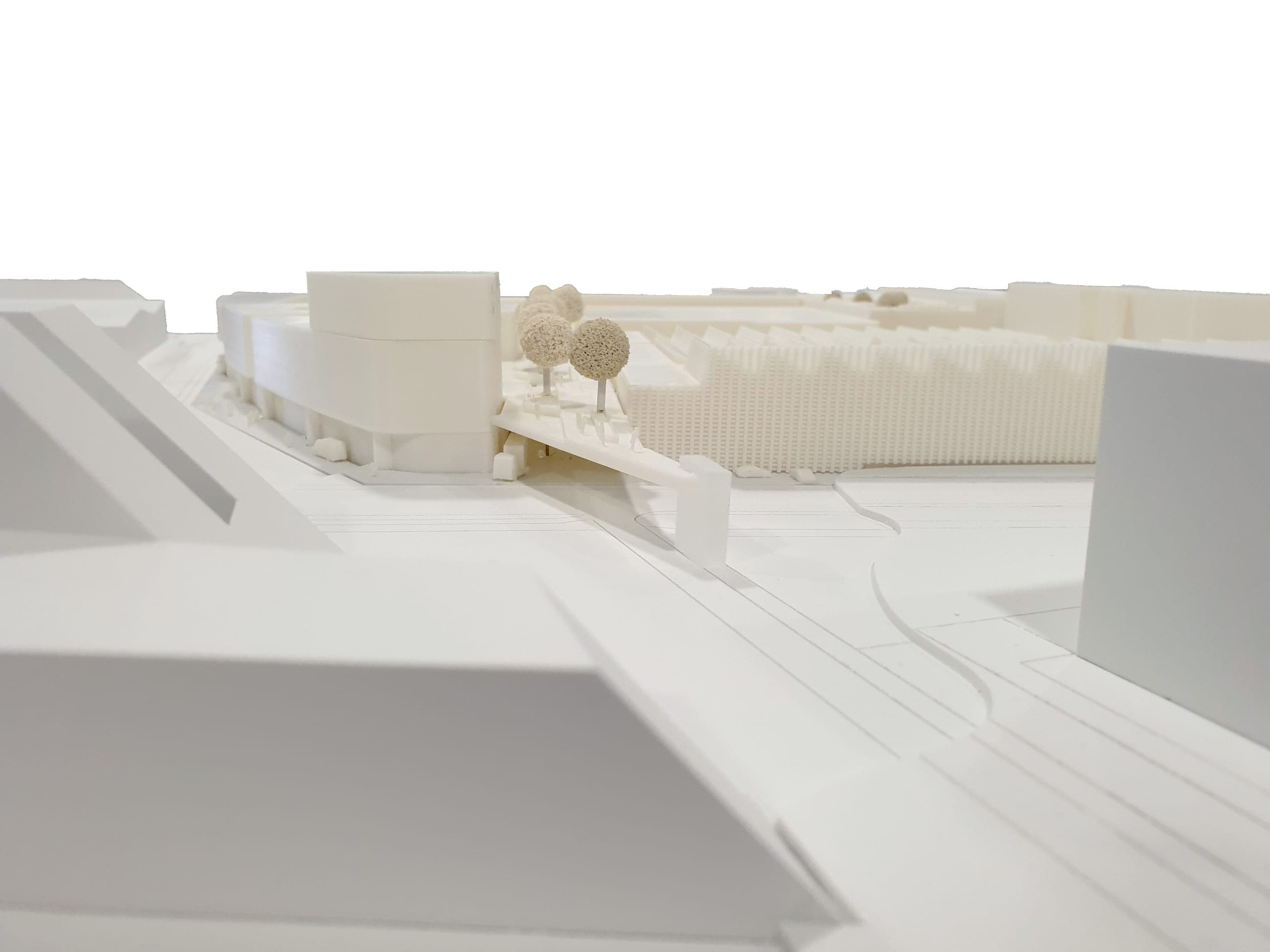 Modellfoto auf Straßenhöhe mit Blick auf die Rampe der Fußgängerbrücke und die Sheddachhallen dahinter