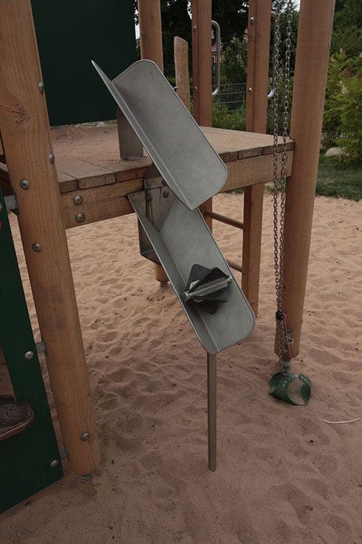 Metal sand chute as a play element on a timber play tower in the sandpit
