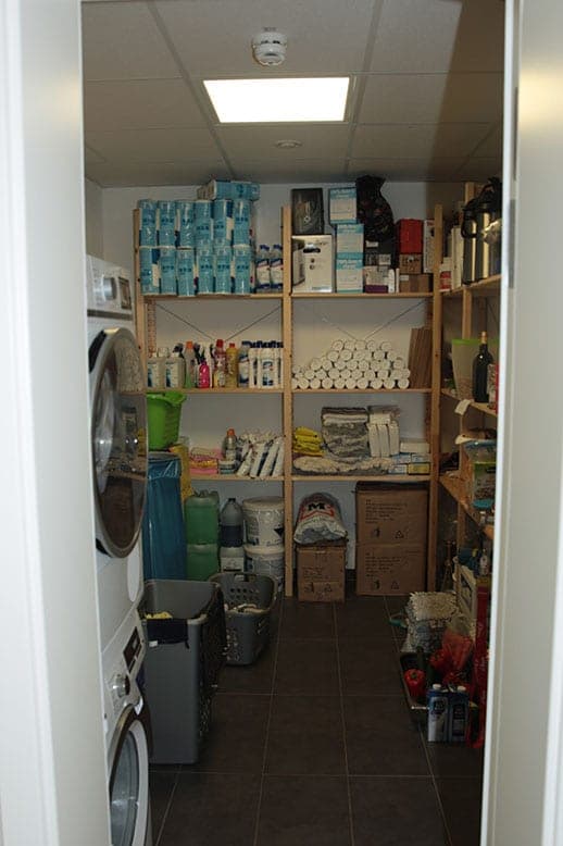 Storage and utility room with timber shelving, a washing machine and a tumble dryer