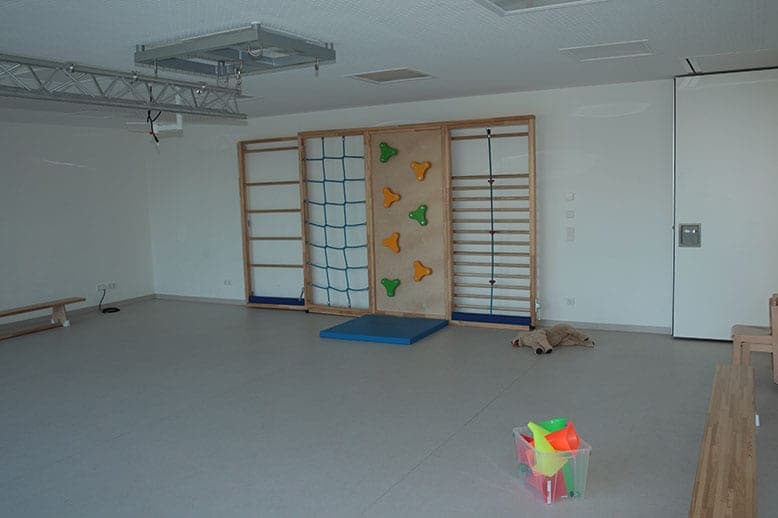 Nursery activity room with wall bars, a climbing net, a climbing wall and gym benches
