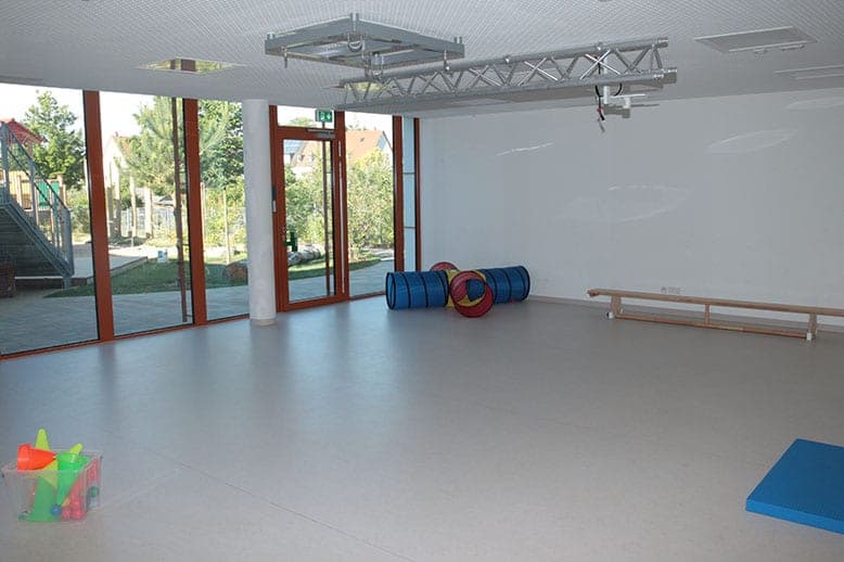 Activity room with play tunnels, a gym bench and a full-height window front to the garden