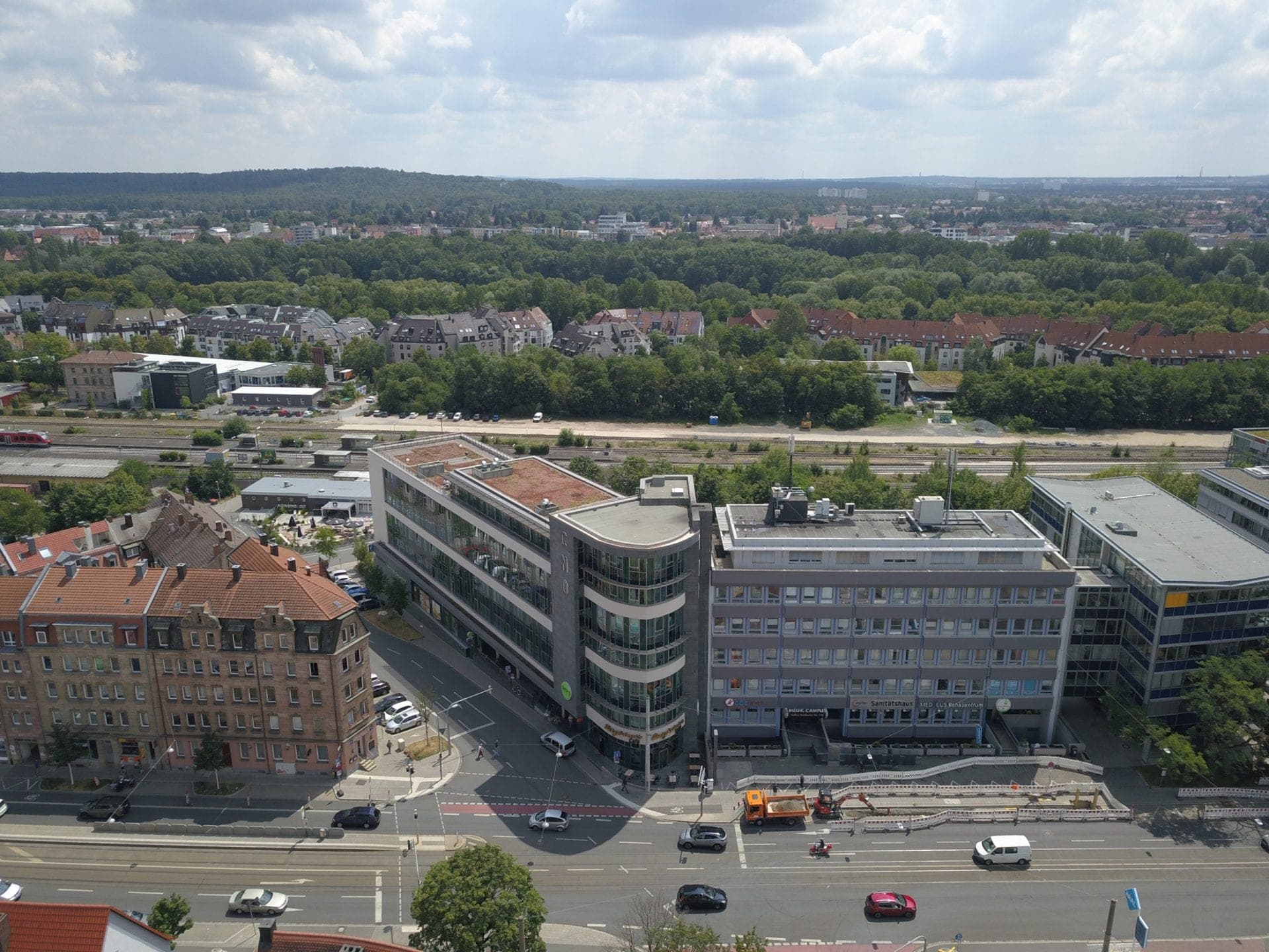 Luftbild des Neubaus an der Äußeren Sulzbacher Straße mit Gründach, dahinter Bahntrasse und Wald