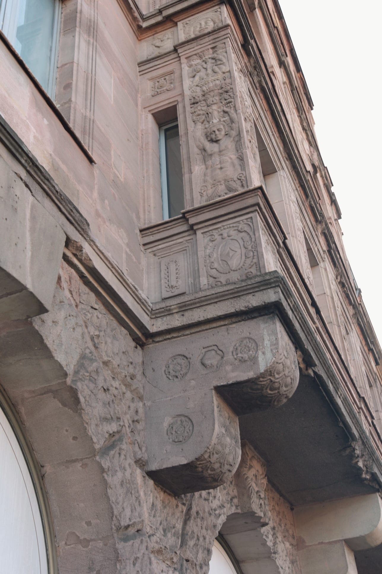 Oriel with a figurative relief and ornamental panels on sandstone corbels, seen from below on the façade