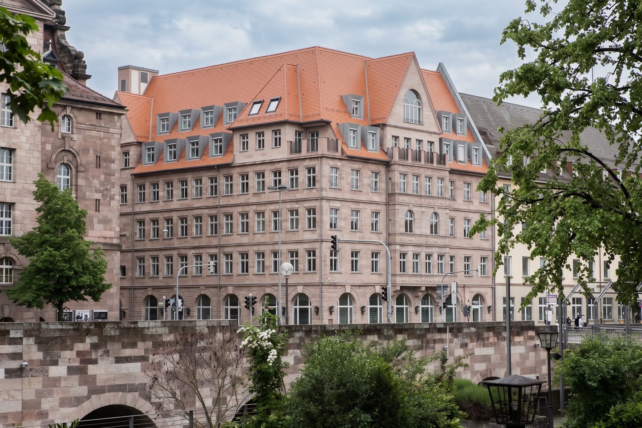 Deutscher Hof office and residential building in Nuremberg, view across a sandstone wall with trees in front