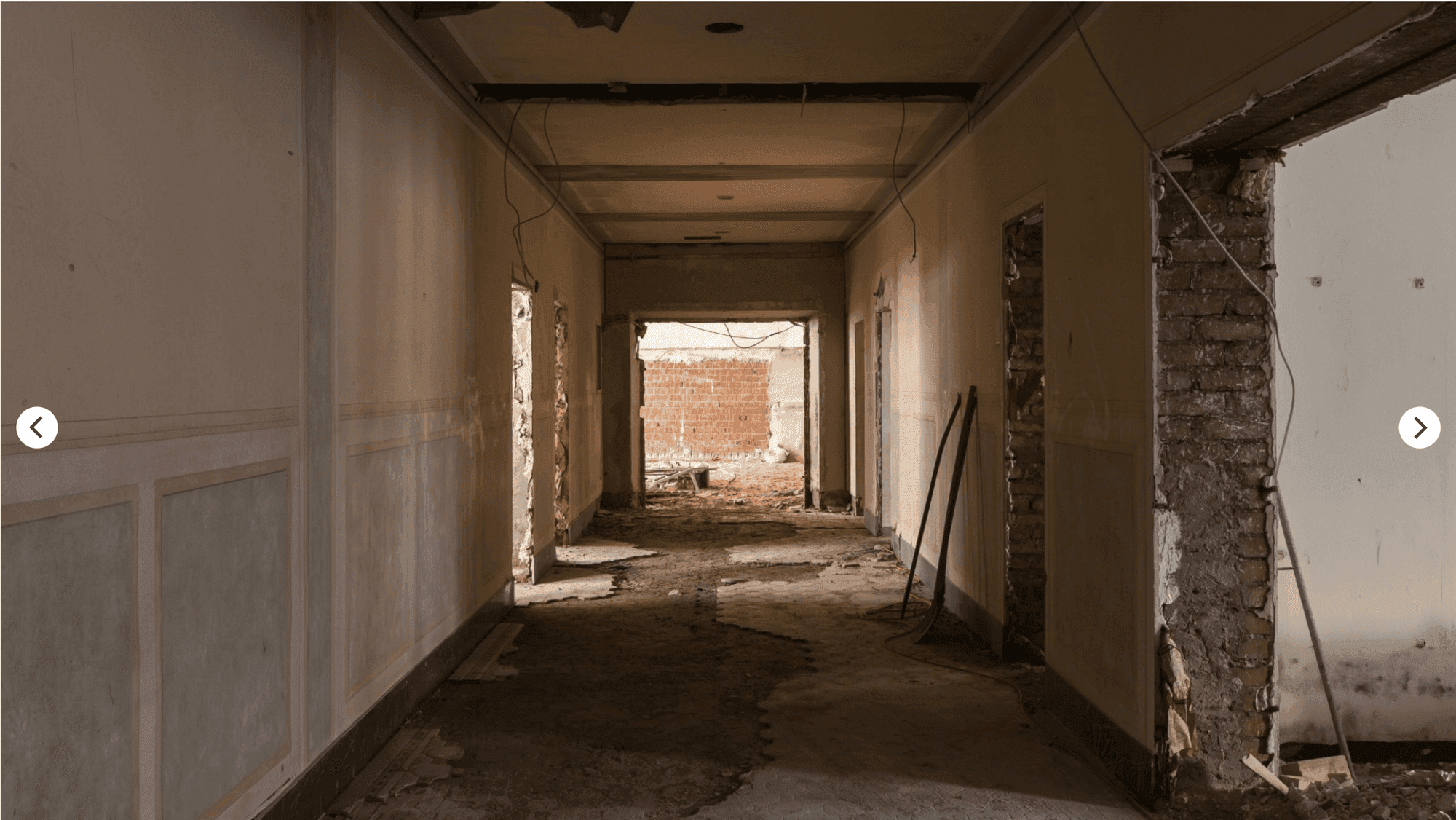 Stripped-out central corridor from the former hotel use with removed plaster and open door openings