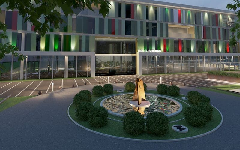 Visualisation of the entrance in evening light with lettering above the foyer and fountain sculpture in the turning circle