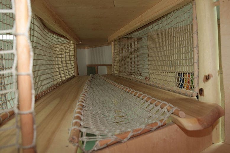 Netztunnel im oberen Geschoss der Kletterlandschaft mit Holzboden und eingespannter Netzmulde