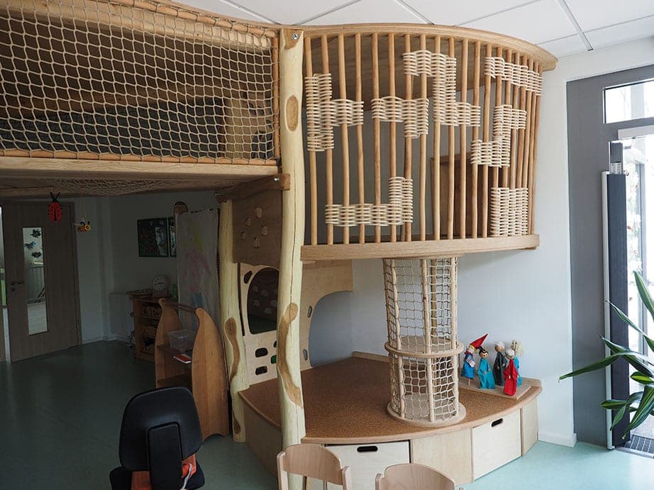 Runder Kletterturm aus Holz mit geflochtenen Elementen, Netzröhre und Podest neben der Netzgalerie