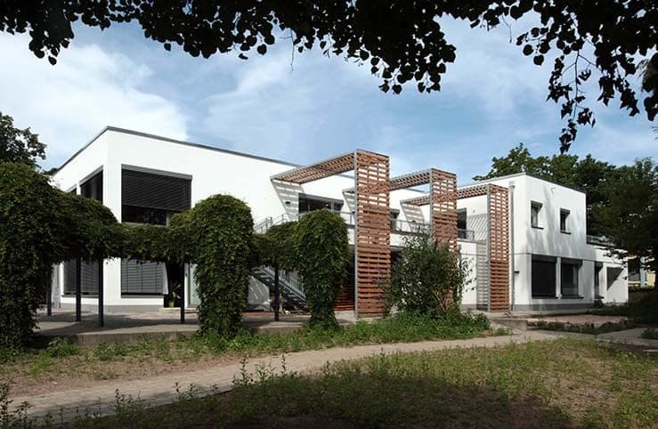Evangelischer Kindergarten und KiTa in Nürnberg, Gartenansicht mit begrünter Pergola und Holzlamellen
