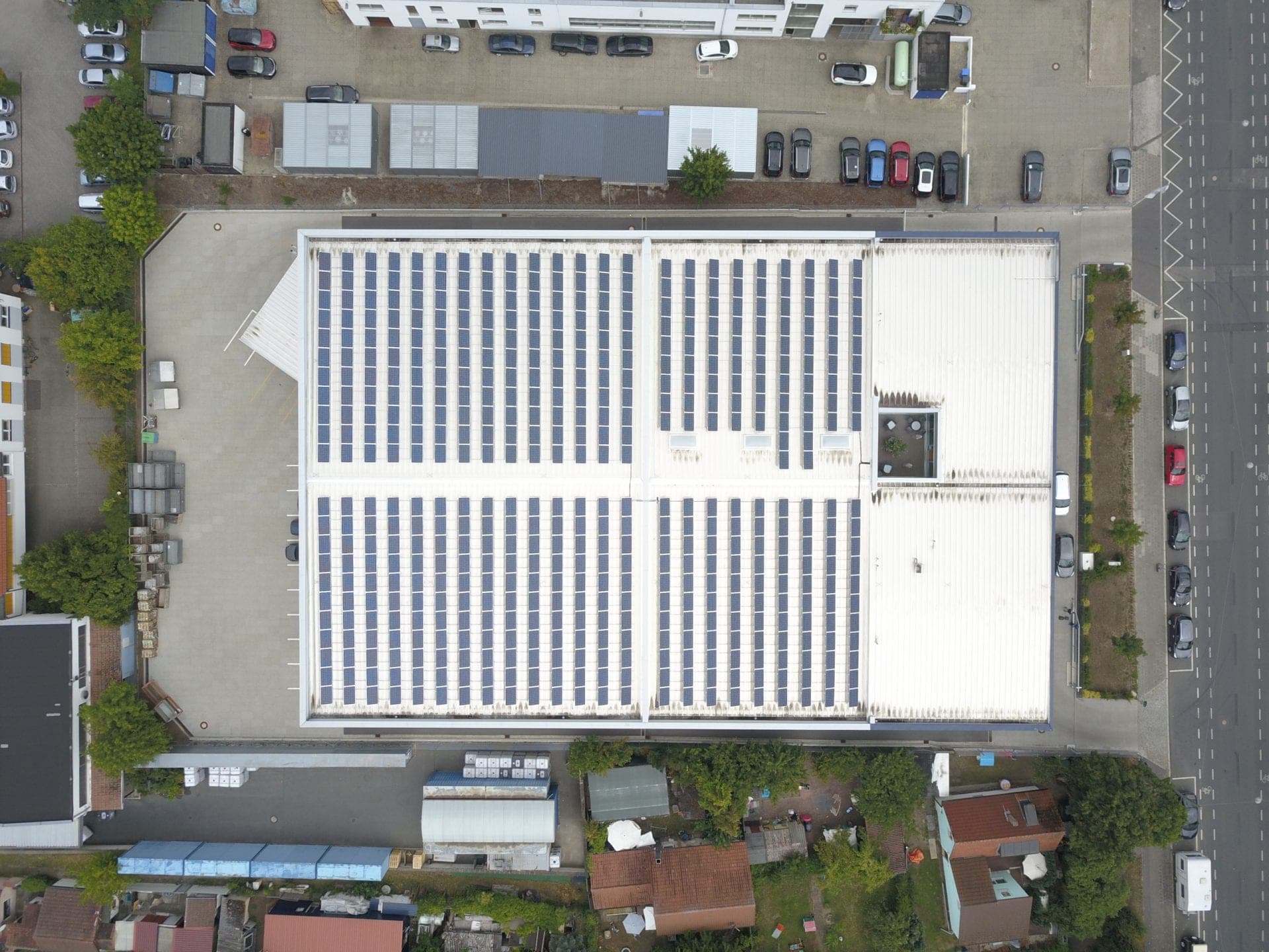 Vertical aerial view of the hall roof with photovoltaic panels and the square opening above the courtyard