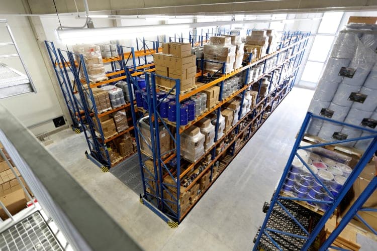 View from a gallery onto blue pallet racking stacked with packaged goods in the warehouse