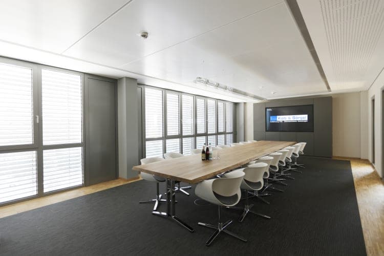 Meeting room from another angle with the wooden table in front of the window front with blinds