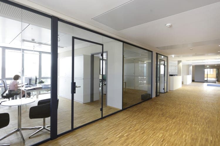 Circulation corridor with glass office partitions and parquet flooring on the administration floor