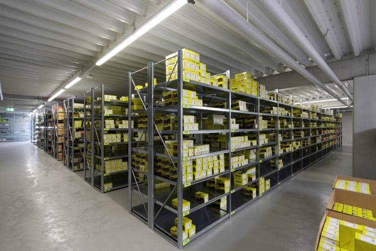 Shelving store with metal racks full of yellow boxes beneath the pale hall ceiling