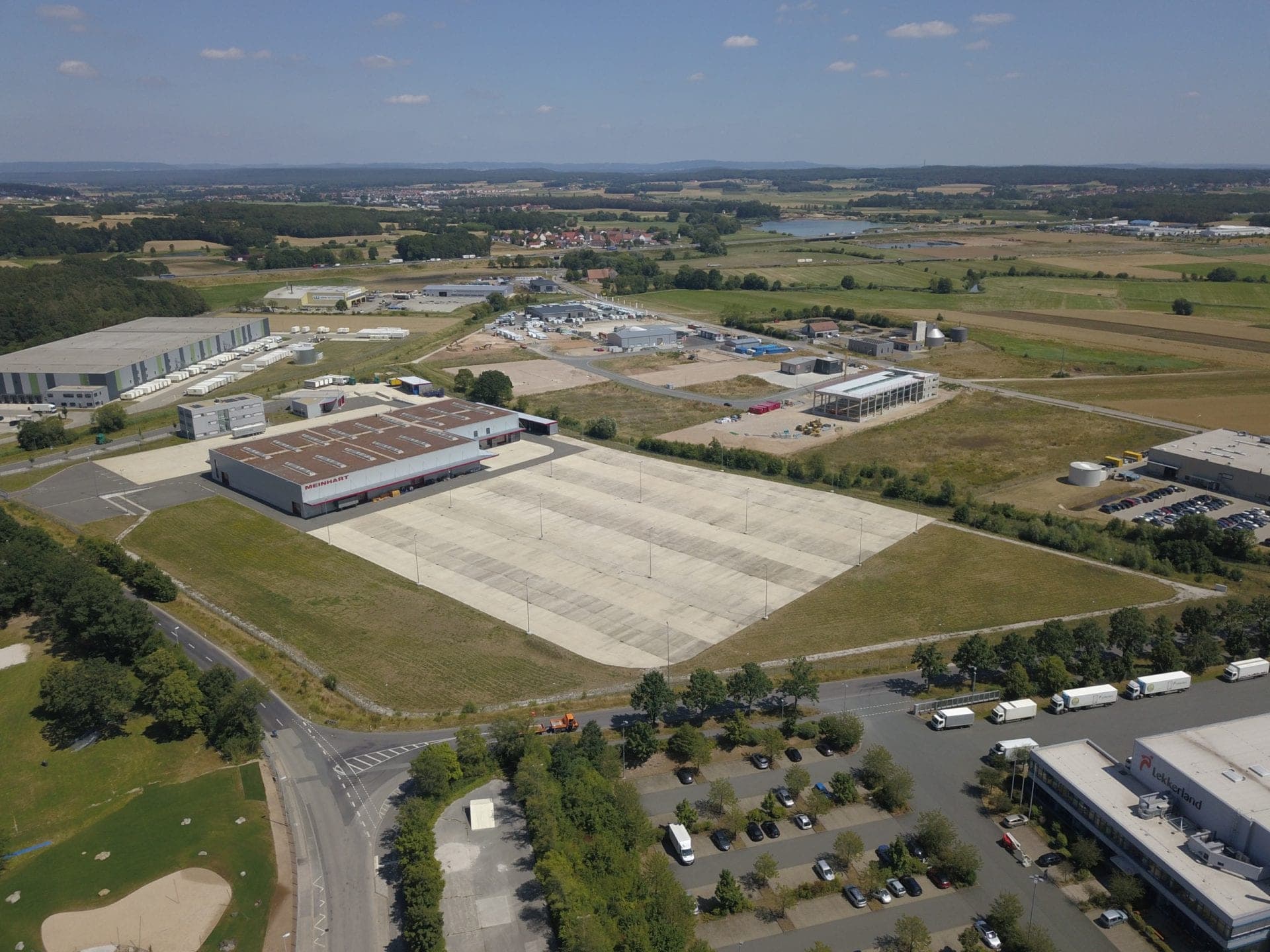 Aerial view of the company site within the business park, looking across the surroundings towards a lake
