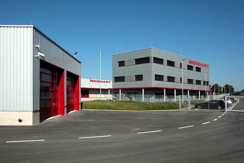 Workshop building with red sectional doors and the office building behind it in Höchstadt a.d. Aisch