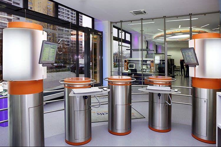 Self-service terminals with screens and keyboards on stainless steel columns in the glazed entrance area