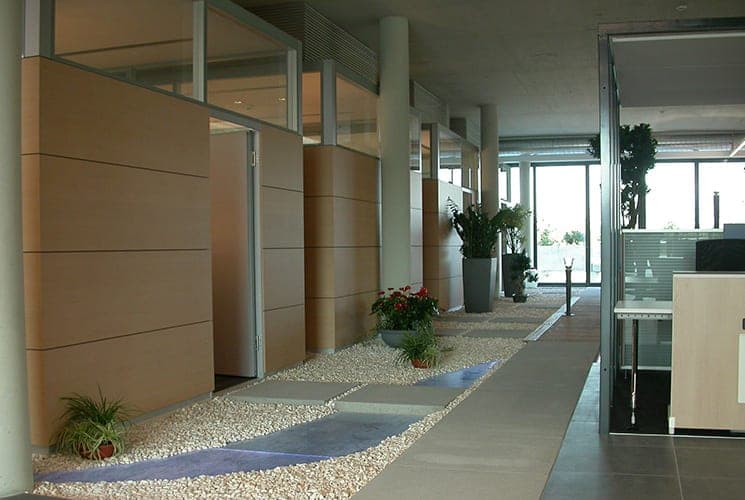 Circulation corridor with timber-clad room pods, a gravel bed, water rill and stepping slabs