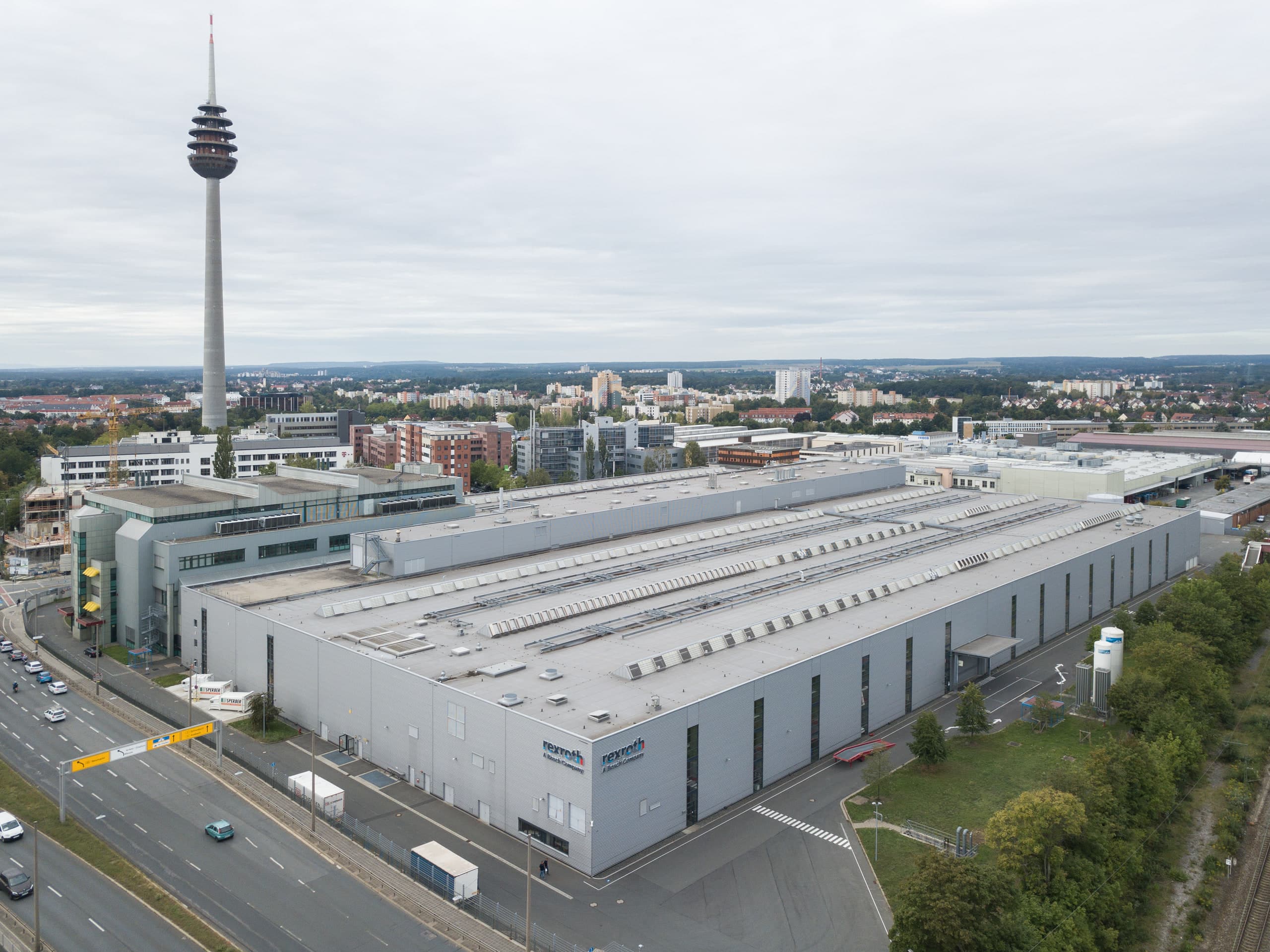 Luftaufnahme der Fertigungshalle mit Blick zum Nürnberger Fernsehturm im Hintergrund.