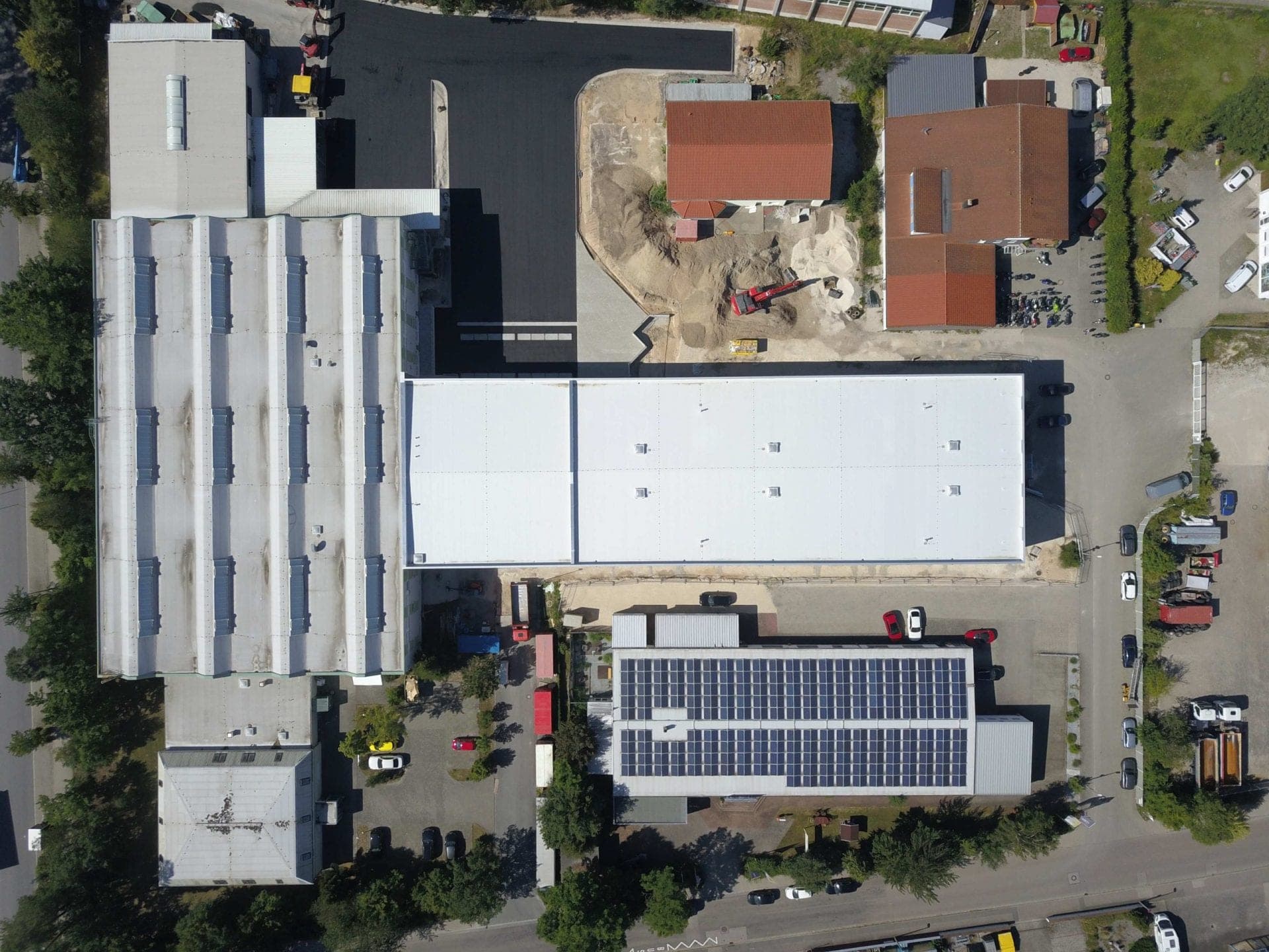 Bird's-eye view straight down onto the high-bay warehouse in Roth, existing halls with solar roof and neighbouring plot