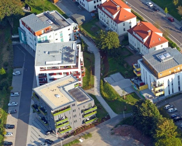 Aerial view of the residential park with several apartment buildings, flat roofs and adjacent development