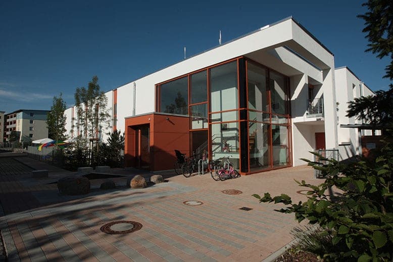 CJD day nursery in Nuremberg, view across the paved forecourt to the glazed entrance area