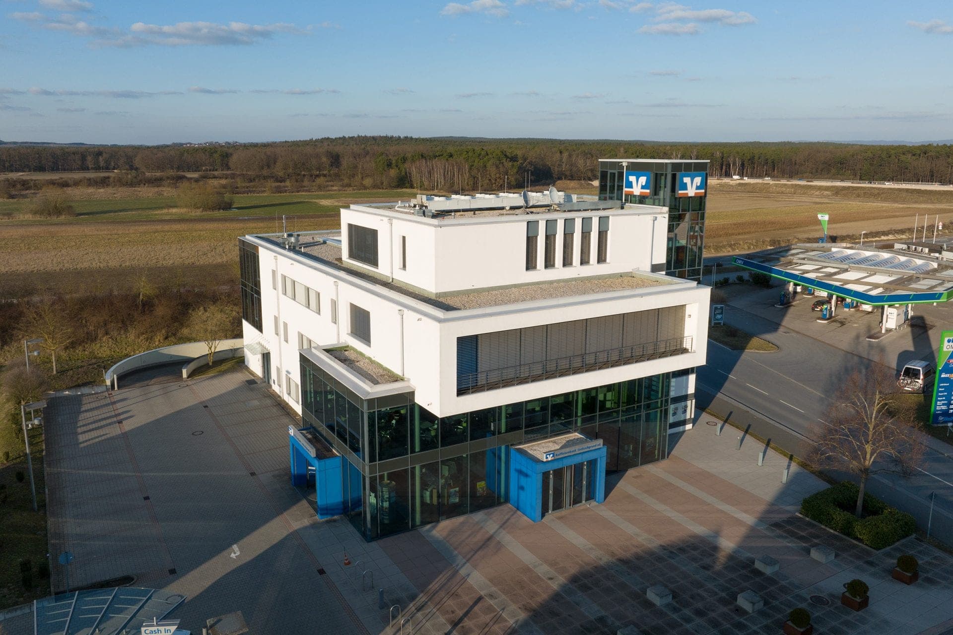 Bank building for Raiffeisenbank Seebachgrund in Hessdorf, aerial view with glazed tower, forecourt and blue entrances