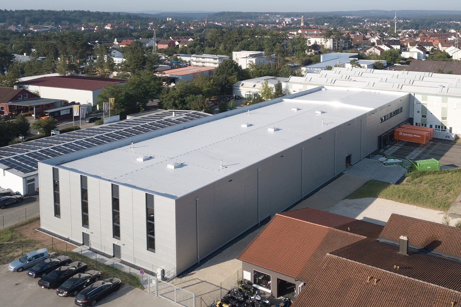Hochregallager Riffelmacher & Weinberger in Roth bei Nürnberg, Luftbild mit grauer Fassade und Bestandsgebäuden